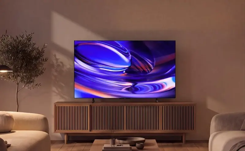 The Sony Bravia 6 OLED TV on a table in a living room at night.