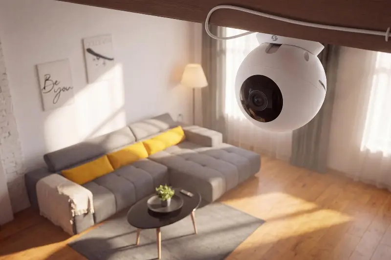 A white version of the Shelly Camera mounted to a ceiling above a living room.