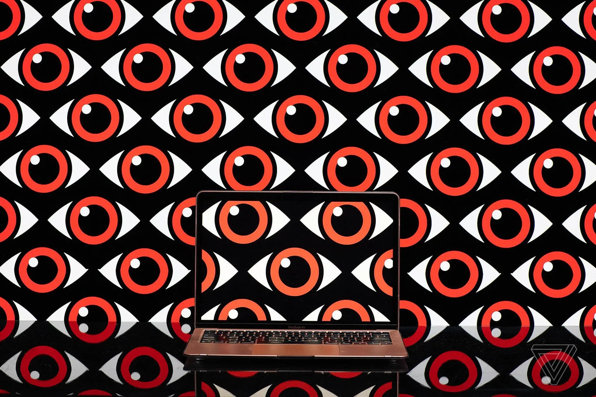 Art depicting a pattern of repeating eyeballs over a computer screen.