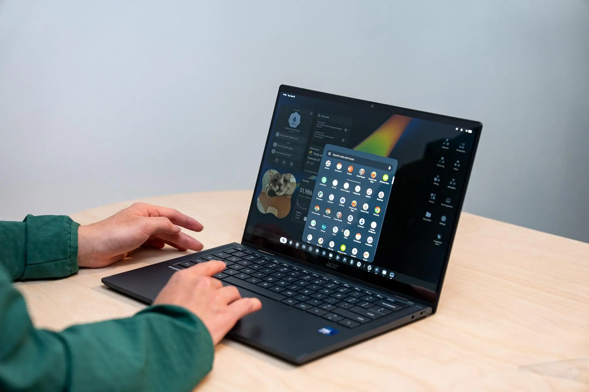 A person using an Acer Googlebook 14 laptop on a wood table.