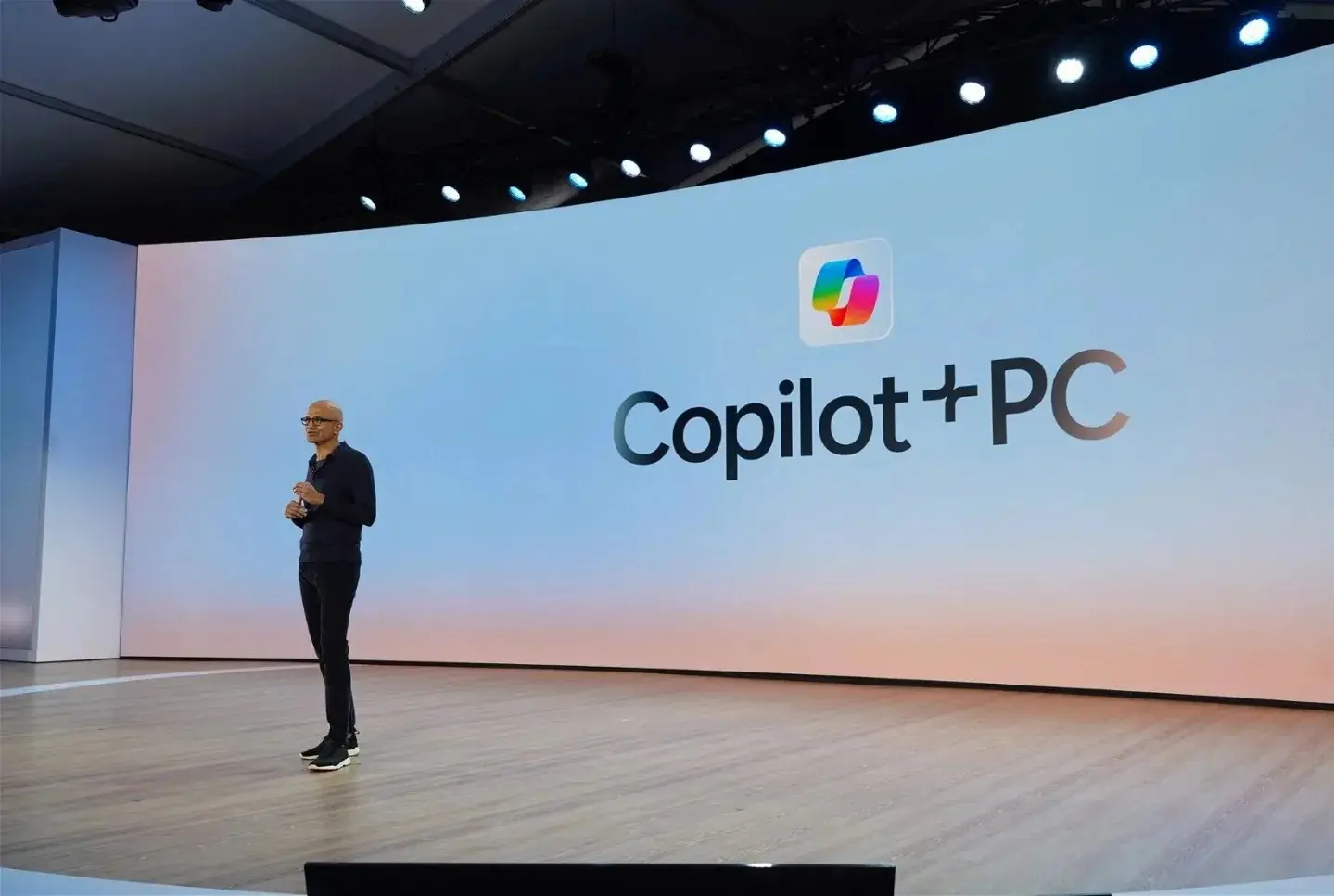 A photo of Microsoft CEO Satya Nadella with the text “Copilot+ PC” in the background