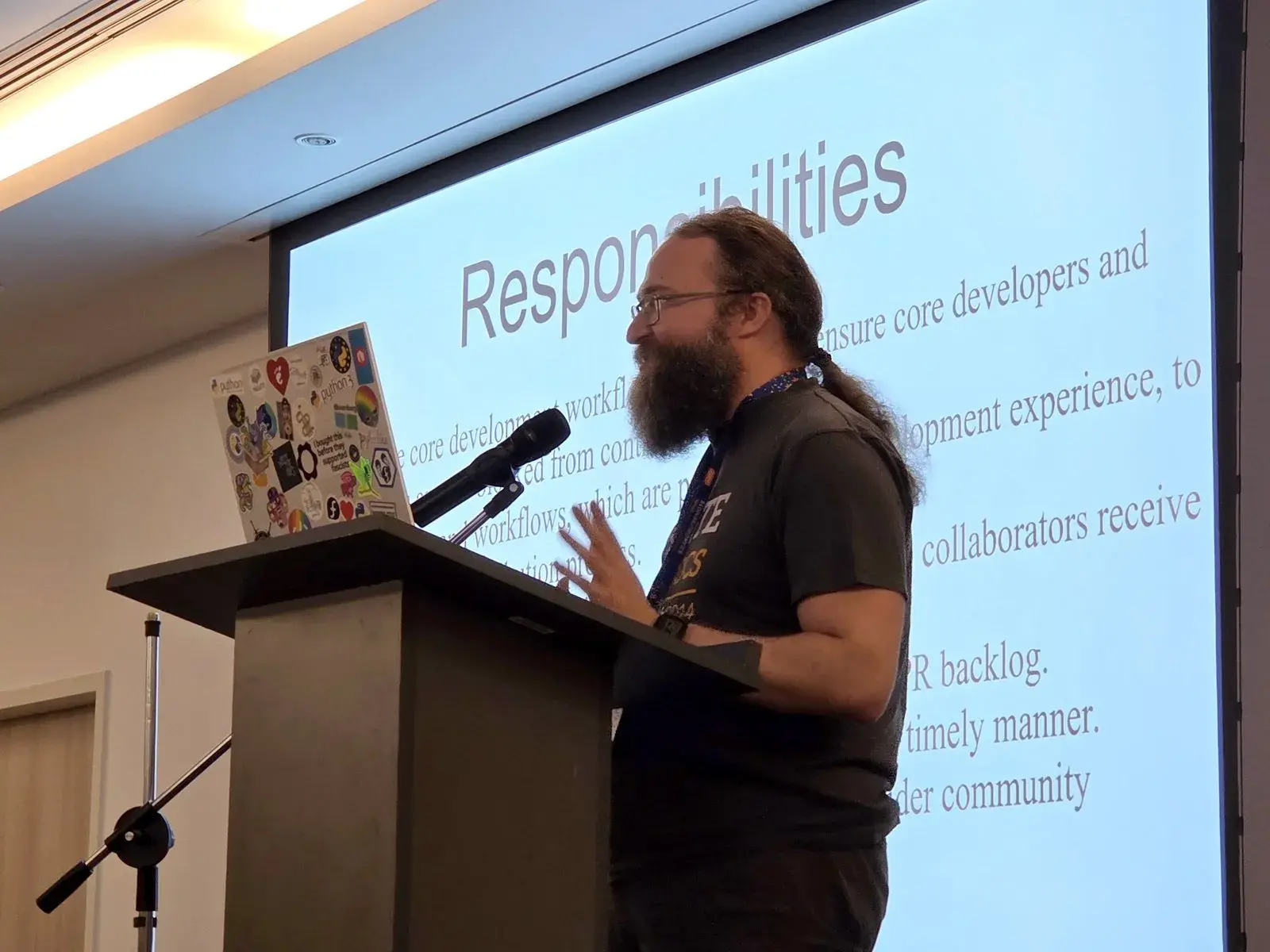 Petr Viktorin speaking at the lectern in front of a slide titled “Responsibilities”
