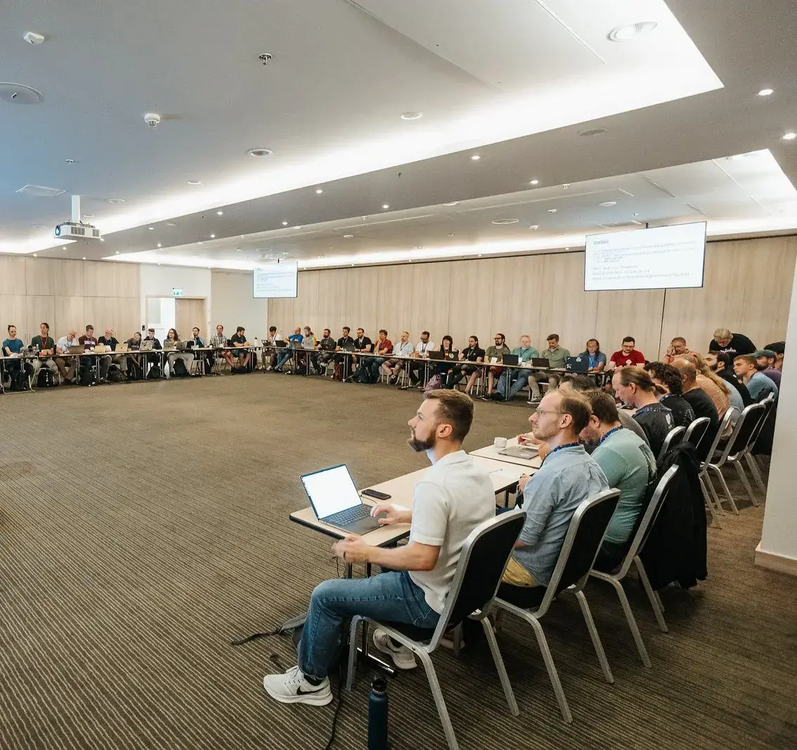 A wide view of the Language Summit room, with attendees around the U-shaped table