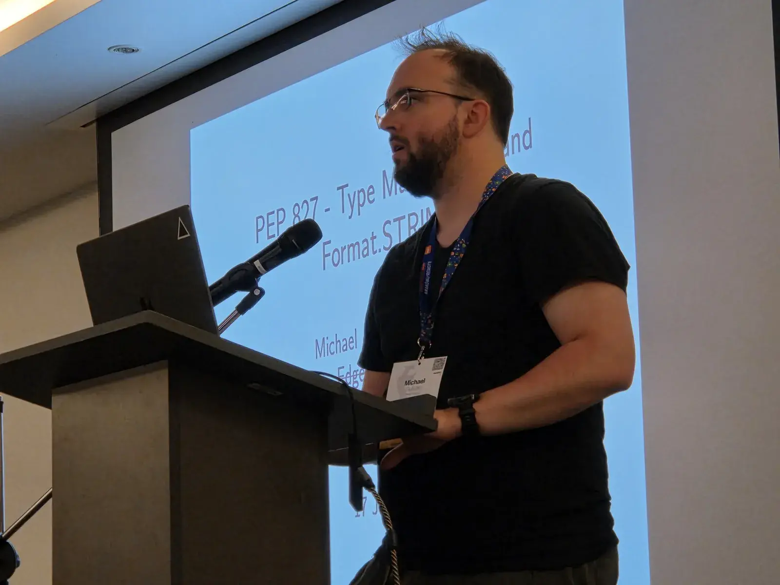 Michael J. Sullivan at the lectern, in front of his PEP 827 title slide