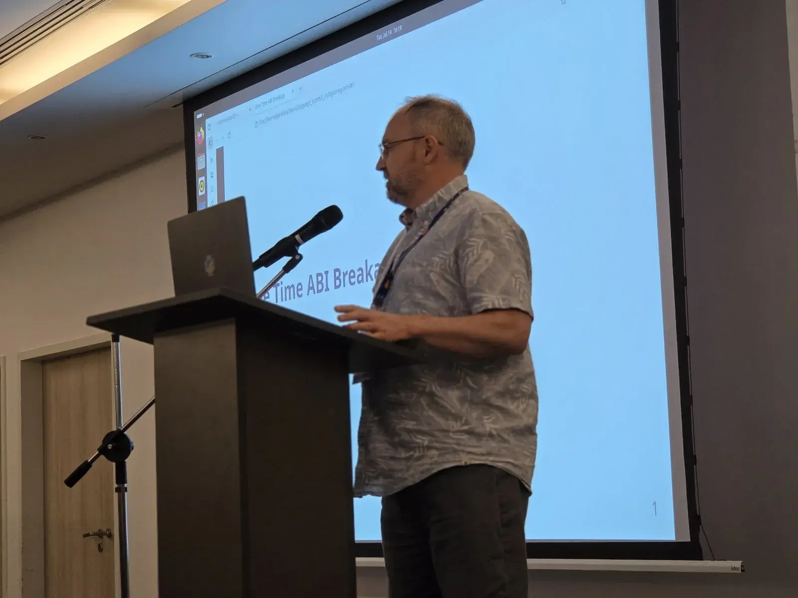 Mark Shannon at the lectern, in front of his “One Time ABI Breakage” slide