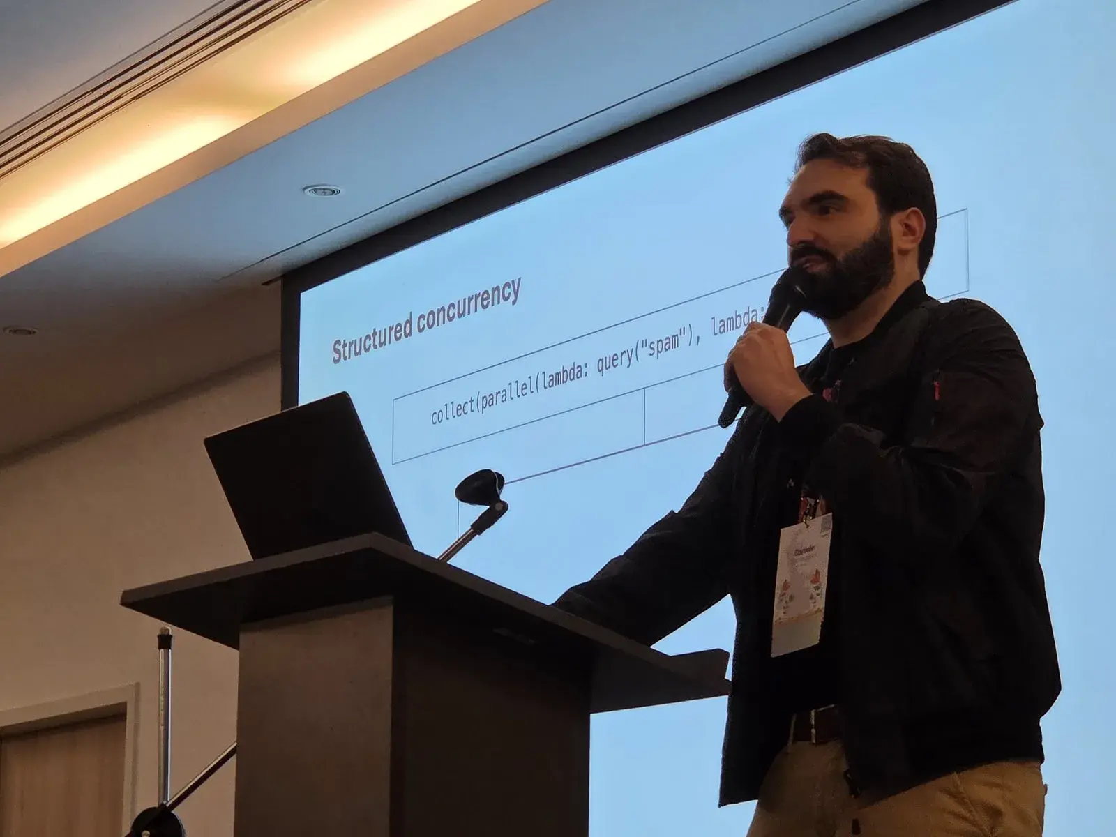 Daniele Parmeggiani at the lectern, in front of his “Structured concurrency” slide