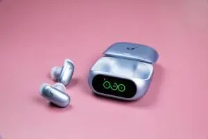 The blue Soundcore Liberty 5 Pro earbuds sitting next to their open case on a mauve background.
