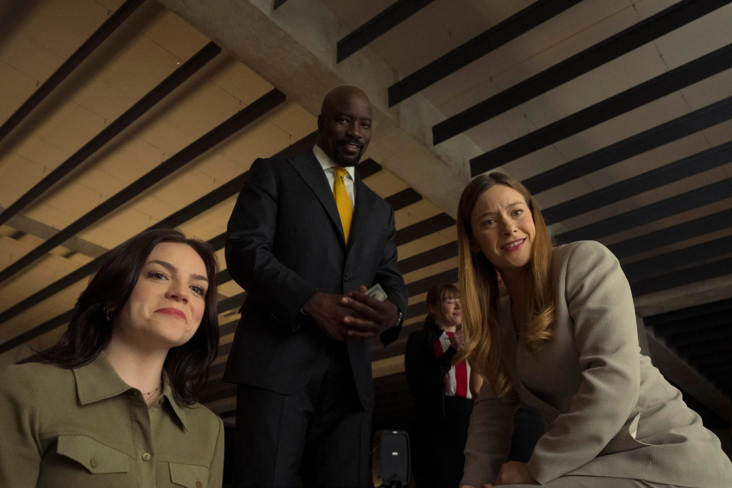 Three people in office wear from below looking down.