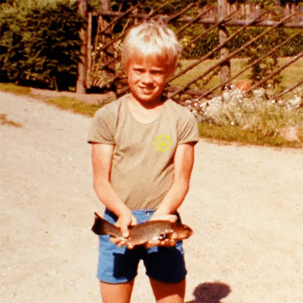 A young boy holding a fish