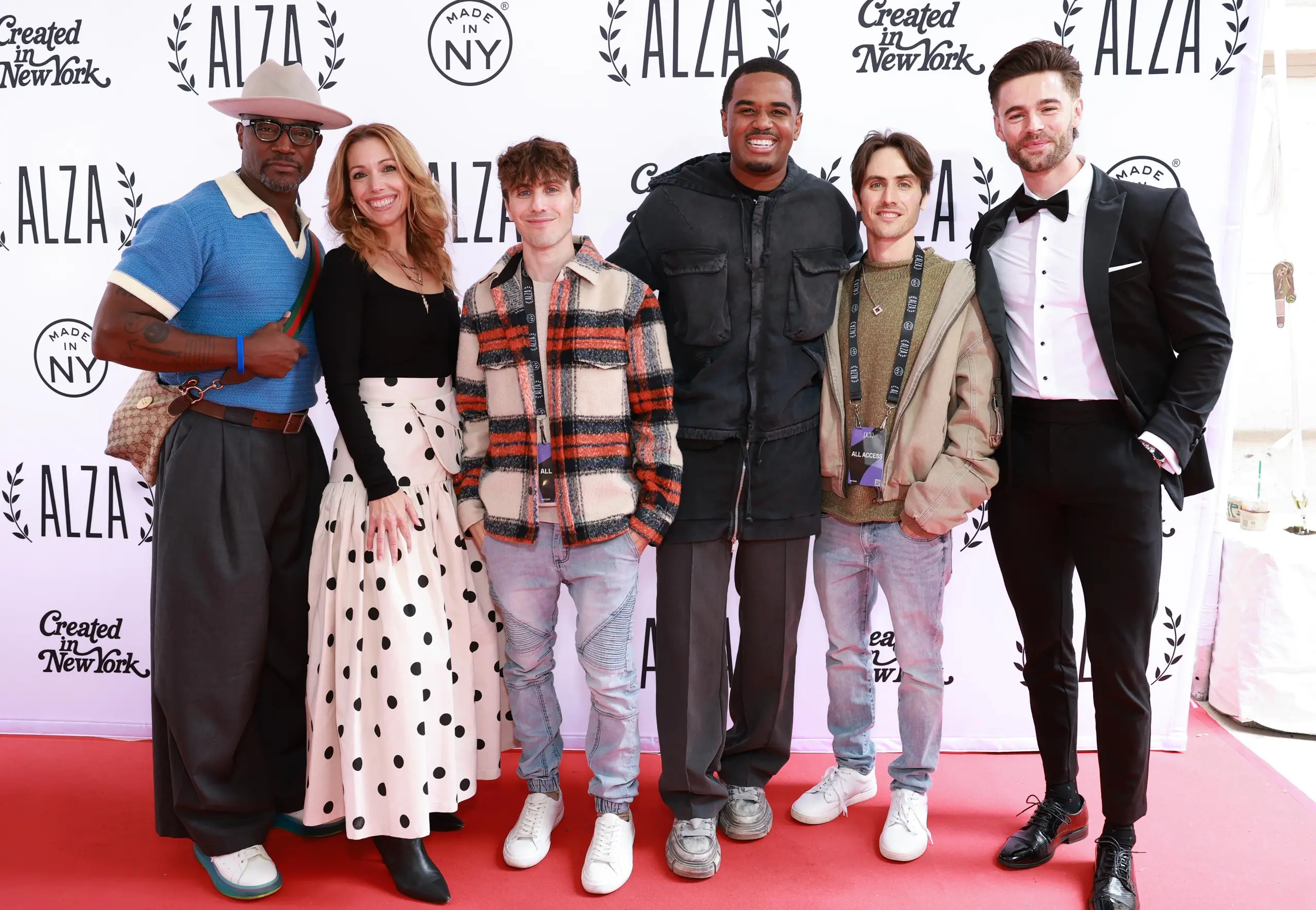 Actors Taye Diggs, Autumn Federici, Gary Entin, Troy Brookins, Edmund Entin and Eric Guilmette standing on a red carpet together.