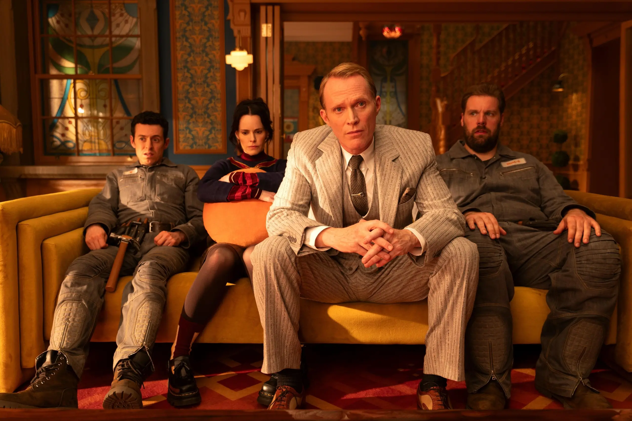 Four characters from VisionQuest are seated on a couch in a living room.