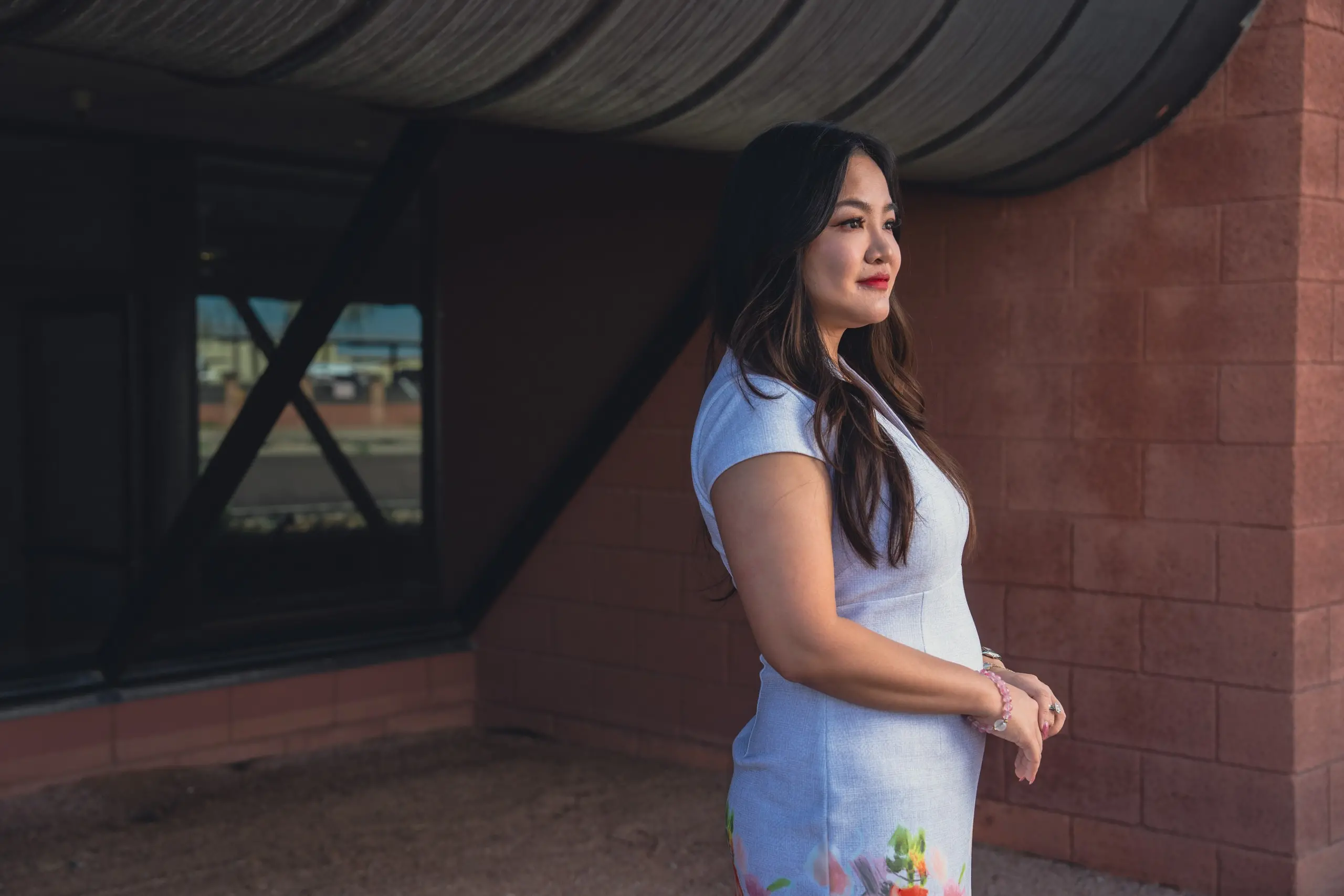 Rebecca Chan stands in front of a warehouse window.