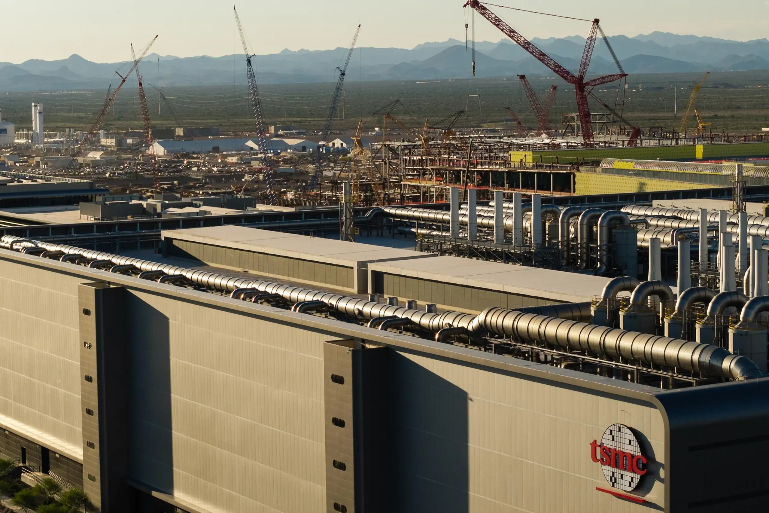Aerial view of the TSMC building with cranes in the distance.