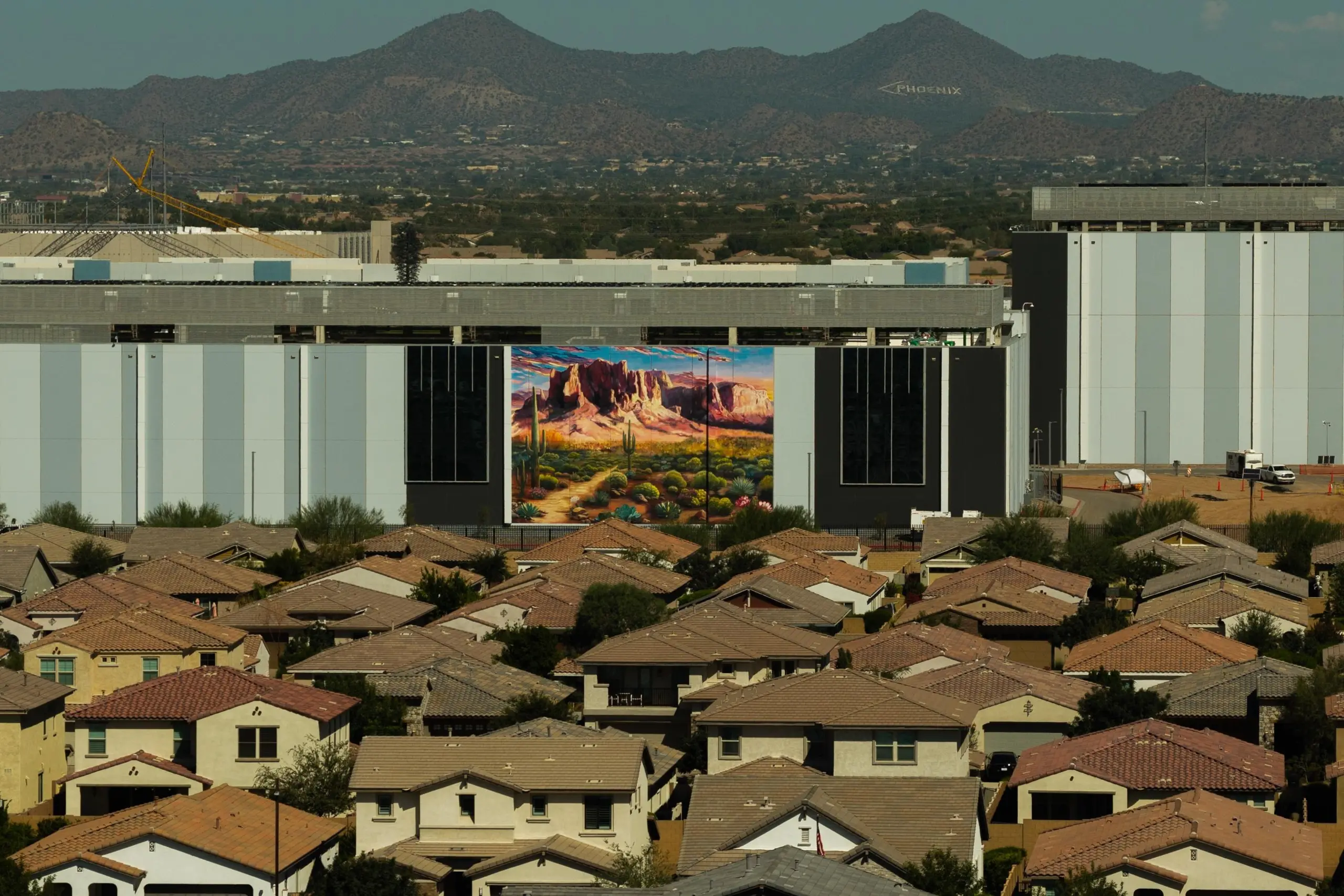 Housing near the Edgecore PH03 data center in Mesa, Arizona, the largest data center in Arizona. The building is approximately 600,000 square feet and has several murals on the side facing the neighborhood.