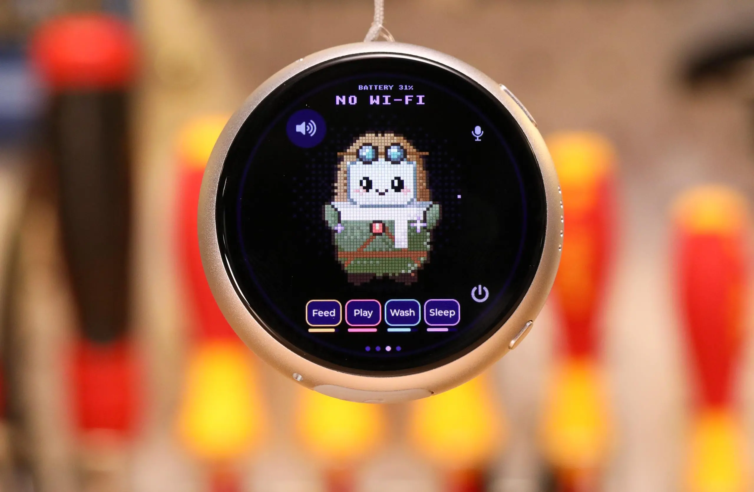 A silver pendant touchscreen computer with a cute little tamagotchi like mascot on screen.